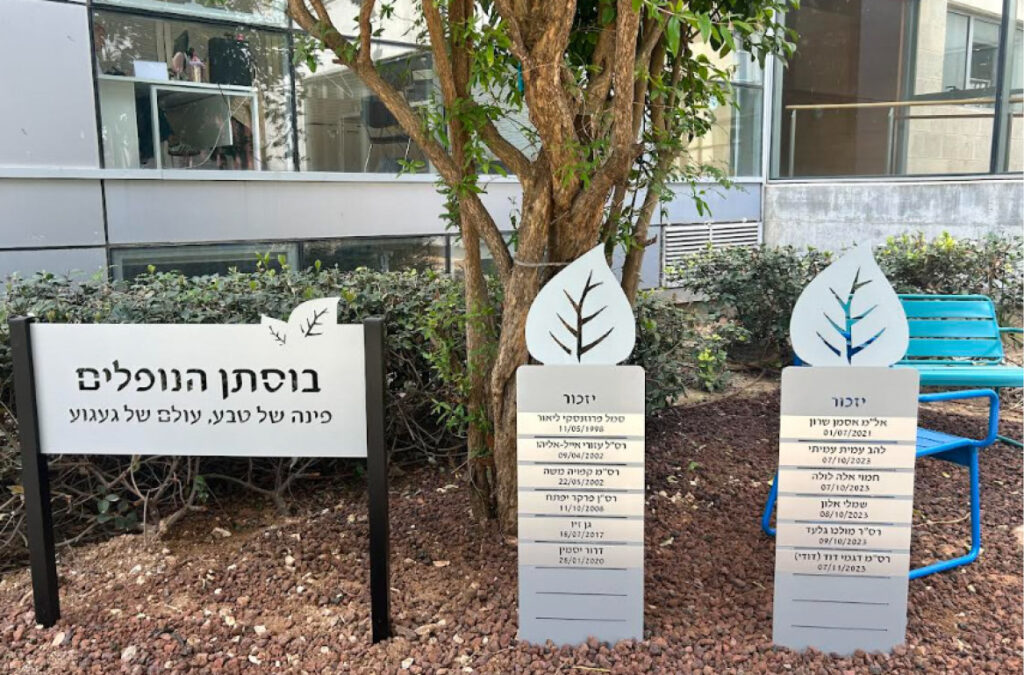 בוסתן הנופלים במכללה האקדמית תל אביב–יפו: שלט ועליו ״בוסתן הנופלים — פינה של טבע, עולם של געגוע״, ולצידו שני עמודי זיכרון בצורת עלה ועליהם שמות הנופלים, ביניהם ״להב עמית עמיתי 07/10/2023״
